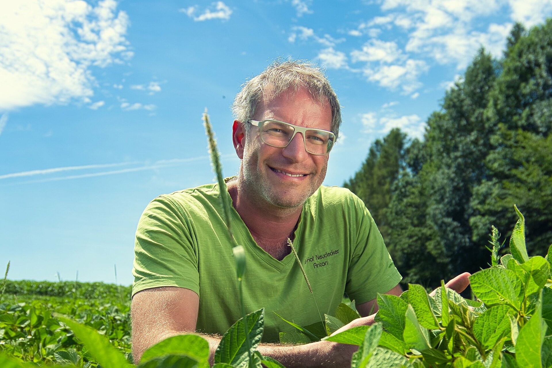 Hockender Landwirt in Sojabestand. Foto: Tilo Wondollek