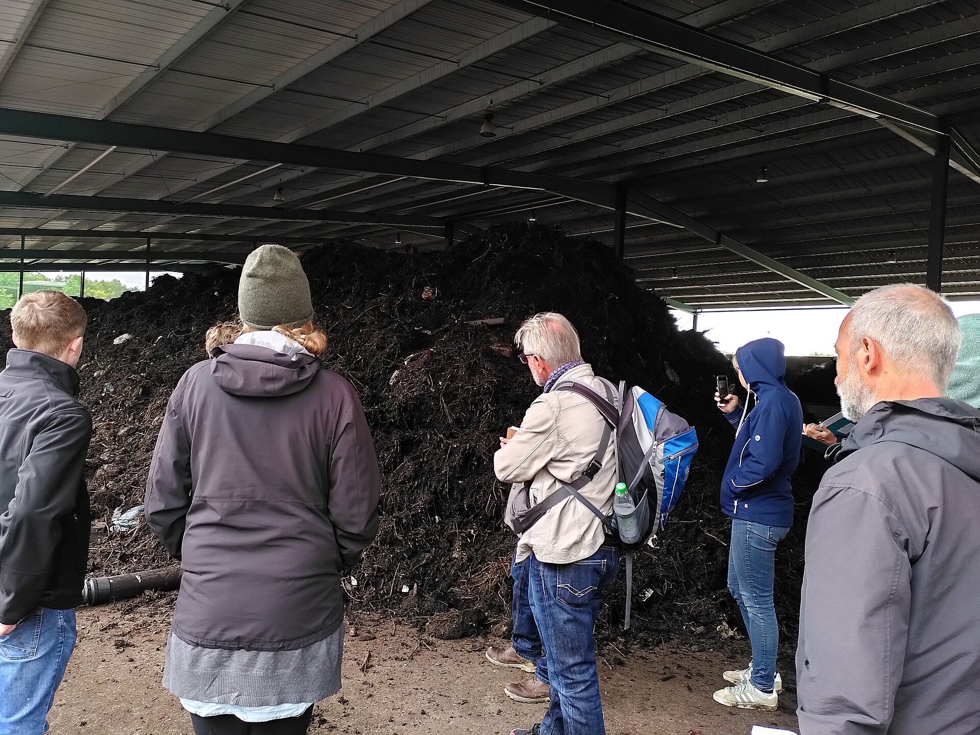 Besucher*innen schauen sich die Komposte an.